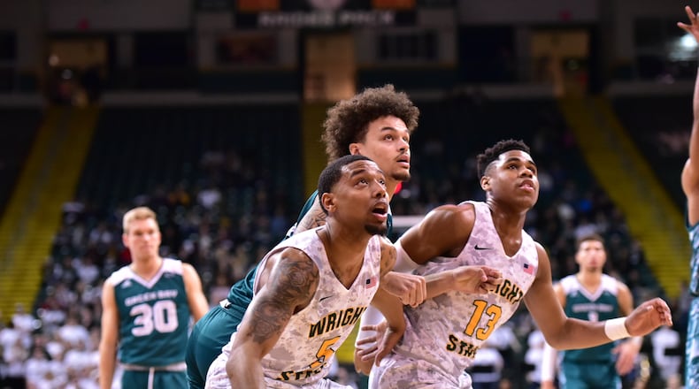 Wright State freshmen Skyelar Potter (left) and Malachi Smith (far right) look to grab a rebound during Saturday’s win over Green Bay. Joseph Craven/CONTRIBUTED