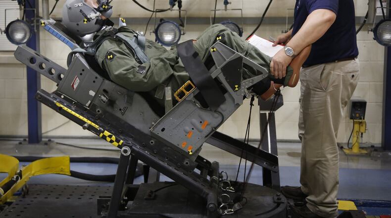 A mannequin is strapped into an ejection seat and secured by Chris Perry at the Aircrew Biodynamics and Protection Facility on Wright-Patterson Air Force Base where it was shot down a rail to measure the gravitational force, or G-force it experiences during a simulated ejection from a jet. The lab has been busy testing a larger envelope of pilot weights, the F-35 Joint Strike Fighter and its new ejection seat. TY GREENLEES / STAFF