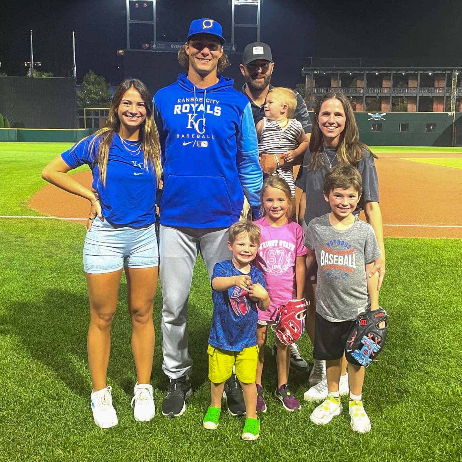 Ryan Weiss (in blue) with his wife Hailey Brooke (to his left) and the family of Wright State baseball coach Alex Sogard and his wife Arlie (on right.) In front (l to r) are Kyler, Penny and Fisher; and Archie is in his dad’s arms. CONTRIBUTED PHOTO