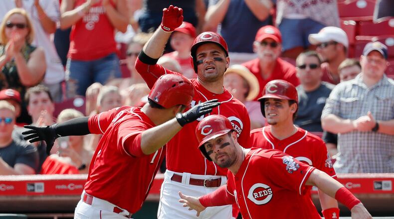 Cincinnati Reds’ Eugenio Suarez, left, celebrates with Jesse Winker, right, after hitting a two-run home run off Pittsburgh Pirates starting pitcher Gerrit Cole in the sixth inning of a baseball game, Sunday, Sept. 17, 2017, in Cincinnati. (AP Photo/John Minchillo)