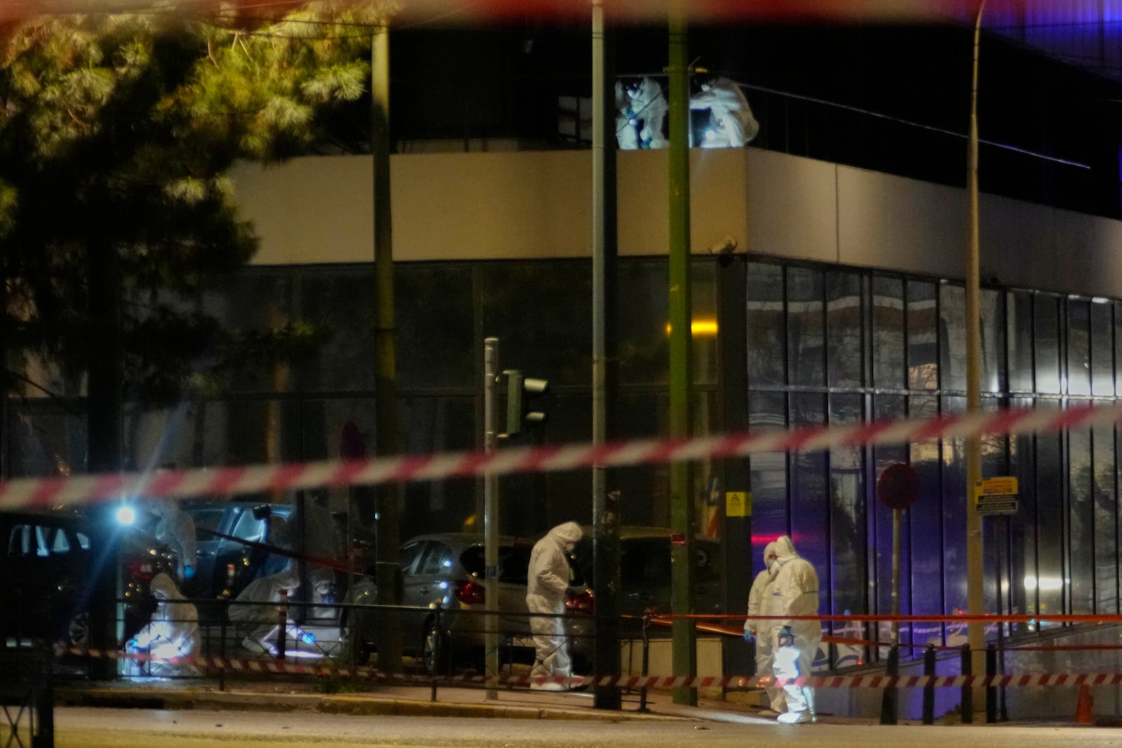 Police officers from the forensics department check the area after a bomb explosion outside of the Hellenic Train offices the company that runs Greece's railway, in Athens, Greece, Friday, April 11, 2025. (AP Photo/Petros Giannakouris)