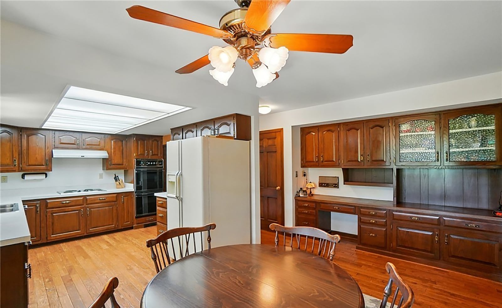 The eat in kitchen has a wall of pantries and built ins including a hutch and planning desk.