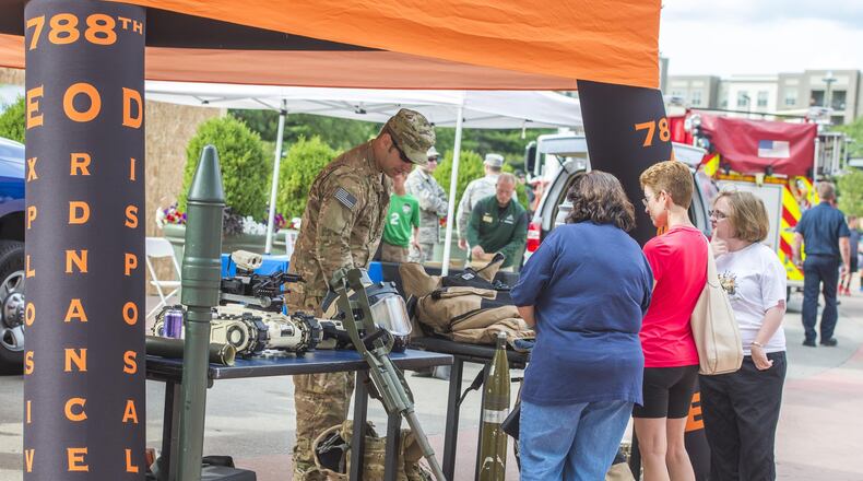 An explosive ordnance technician with the 788th Explosive Ordnance Disposal unit from Wright-Patterson Air Force Base explains his unit’s mission and equipment used which is on display outside Fifth Third Field in downtown Dayton prior to the Dayton Dragons salute to hometown heroes, Aug. 5, 2017. The third annual Wright-Patterson Air Force Base EOD Memorial 5K will be held May 5 on National EOD Day and honors members of the armed forces who have risked their lives disposing of explosives. (U.S. Air Force photo/ Wesley Farnsworth) (Contributed photo)