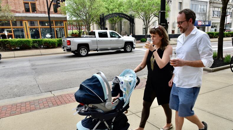 The city of Xenia could have a Designated Outdoor Refreshment Area (DORA) as early as this spring. Many other cities in the region have them, including Dayton, Middletown and Hamilton. Jennifer Acus-Smith and Stephen Smith walk down the sidewalk on High Street on the first day of Hamilton's DORA on May 3, 2020. NICK GRAHAM/STAFF