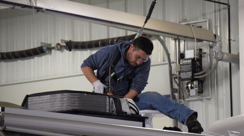 Airstream worker Ryan Buffkin replaces works on finishing up an travel trailer. The company is gearing up to move into its new 750,000 square-foot manufacturing facility in Jackson Center. Currently there are about 960 employees, 600 in manufacturing. The new facility could handle at least double the manufacturing position as market demands. STAFF PHOTO / HOLLY SHIVELY