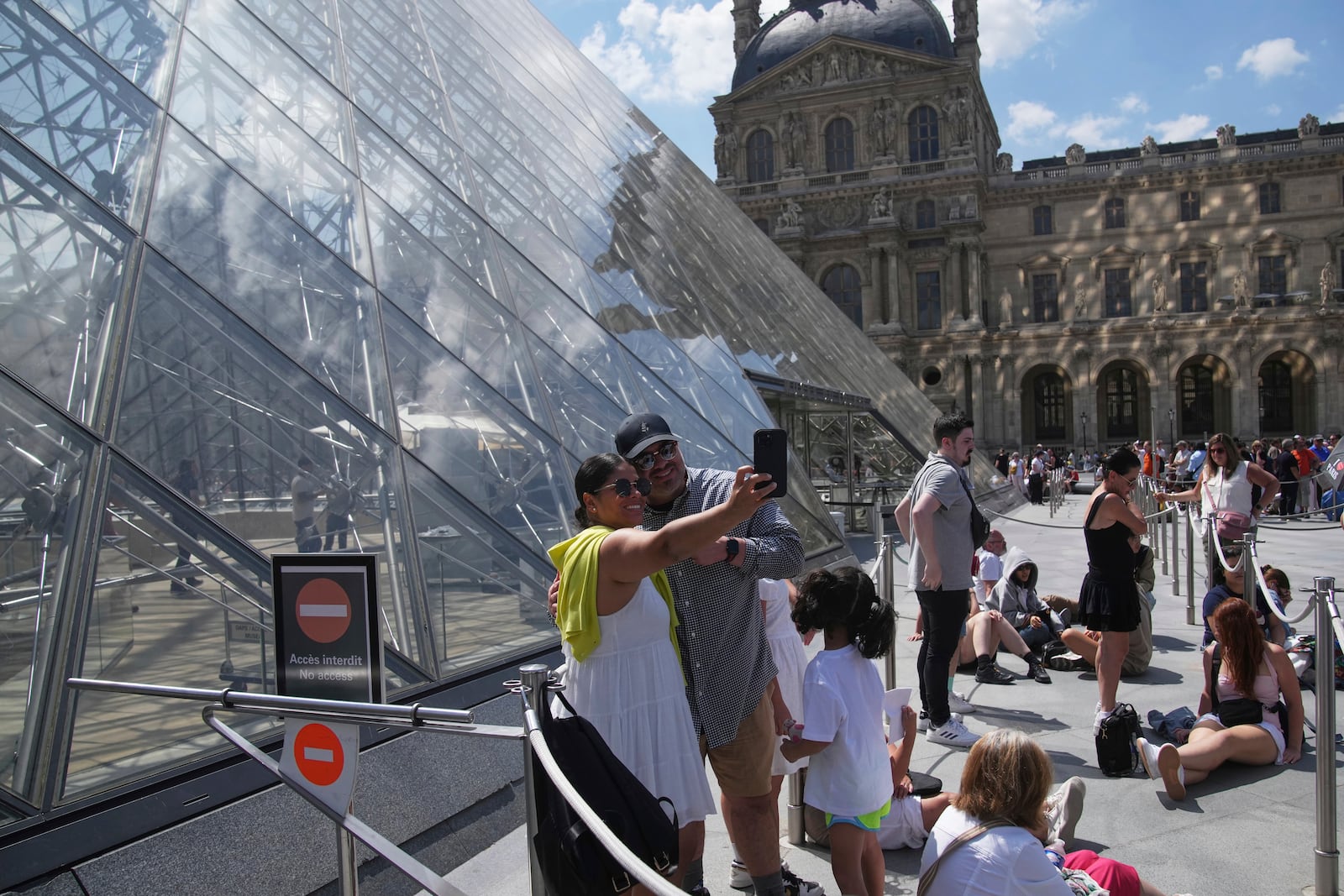 Tourists wait outside the Louvre museum which failed to open on time Monday, June 16, 2025 in Paris. (AP Photo/Christophe Ena)