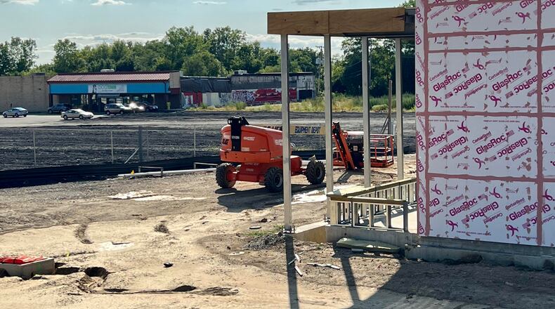 A redevelopment boom is taking place at the former Marian Meadows shopping center site on Brandt Pike in Huber Heights. As construction on the new Dayton Public Library Huber Heights branch continues (right), the city is seeking bids for demolition of the nearby building currently occupied by Dogtown Daycare (rear). AIMEE HANCOCK/STAFF