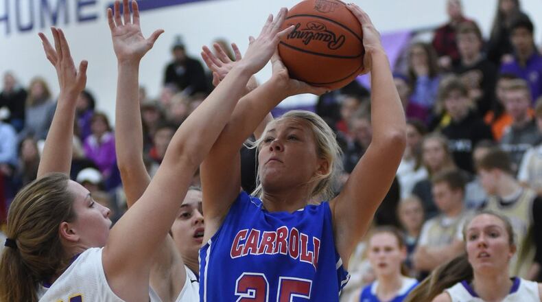 Carroll’s Amanda Schroeder scores over Bellbrook’s Stephanie Dorn in Wednesday night’s girls basketball game at Bellbrook. NICK FALZERANO/CONTRIBUTED