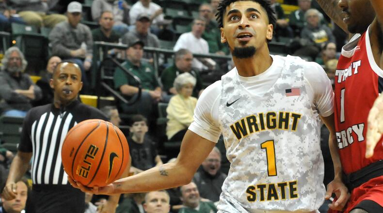 Wright State's Trey Calvin, 1, drives toward the basket against Detroit Mercy's TJ Moss, 1, during a Horizon League game at the Nutter Center on Friday, Jan. 6. DAVID A. MOODIE/CONTRIBUTING PHOTOGRAPHER