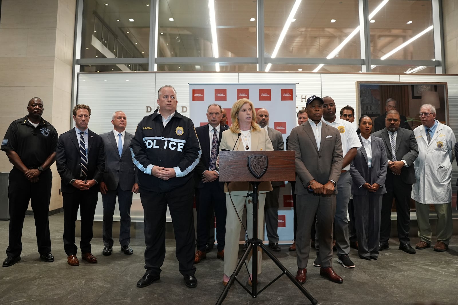 Flanked by New York Mayor Eric Adams, right, and NYPD Chief of Department John Chell, left, New York Police Commissioner Jessica Tisch speaks during a news conference at New York Presbyterian Weil Cornell Medical Center where a police officer was brought after being shot at a Manhattan office building, Monday, July 28, 2025, in New York. (AP Photo/Angelina Katsanis)