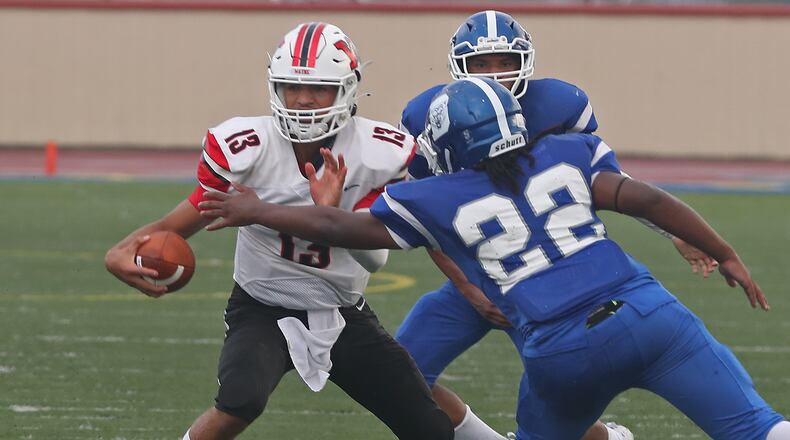 Wayne freshman quarterback Tyrell Lewis tries to avoid a tackle by Dunbar's DaShaun Black during a game on Friday, Aug. 20, 2021. BILL LACKEY/STAFF