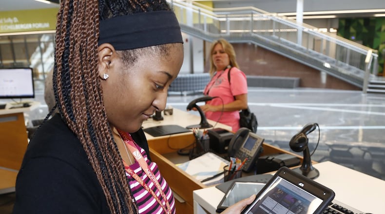 Dayton Metro Library services assistant Destinee Hamilton (CQ) sets up an e-book reader at the main library on East Fifth Street in Dayton. Publishers have added new restrictions and raised the price for libraries who offer their materials which has resulted in fewer offerings from the library. TY GREENLEES / STAFF