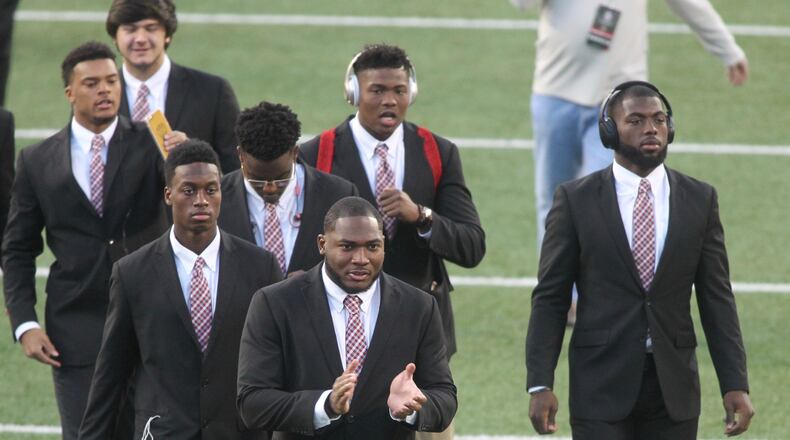 Ohio State players, including Tyquan Lewis, front center, and J.T. Barrett, right, arrive at Ohio Stadium before a game against Nebraska on Saturday, Nov. 5, 2016, in Columbus. David Jablonski/Staff