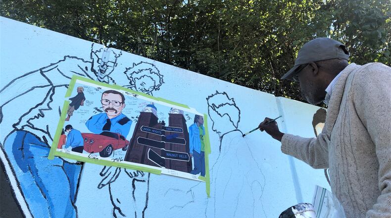 Artist Morris Howard works on the new Steve Whalen memorial mural in southeast Dayton on Friday. CORNELIUS FROLIK / STAFF