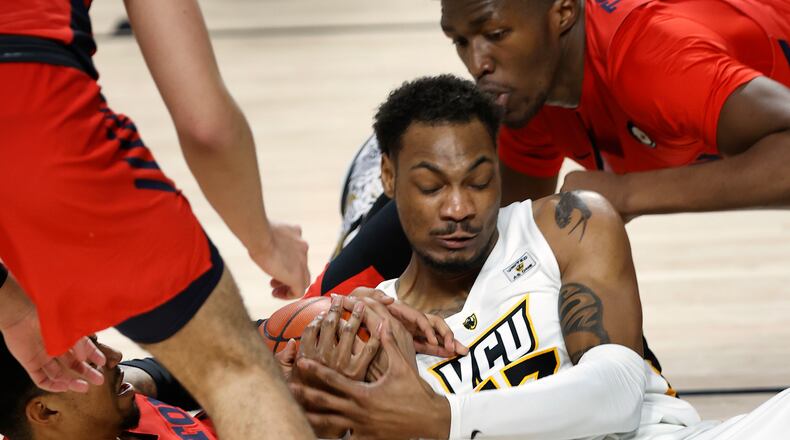 VCU's Corey Douglas Jr. and Dayton's Ibi Watson, left, and Jordy Tshimanga vie for a loose ball in the Siegel Center in Richmond, Va., Sat., Jan. 23, 2021. Alexa Welch Edlund/Richmond Times-Dispatch