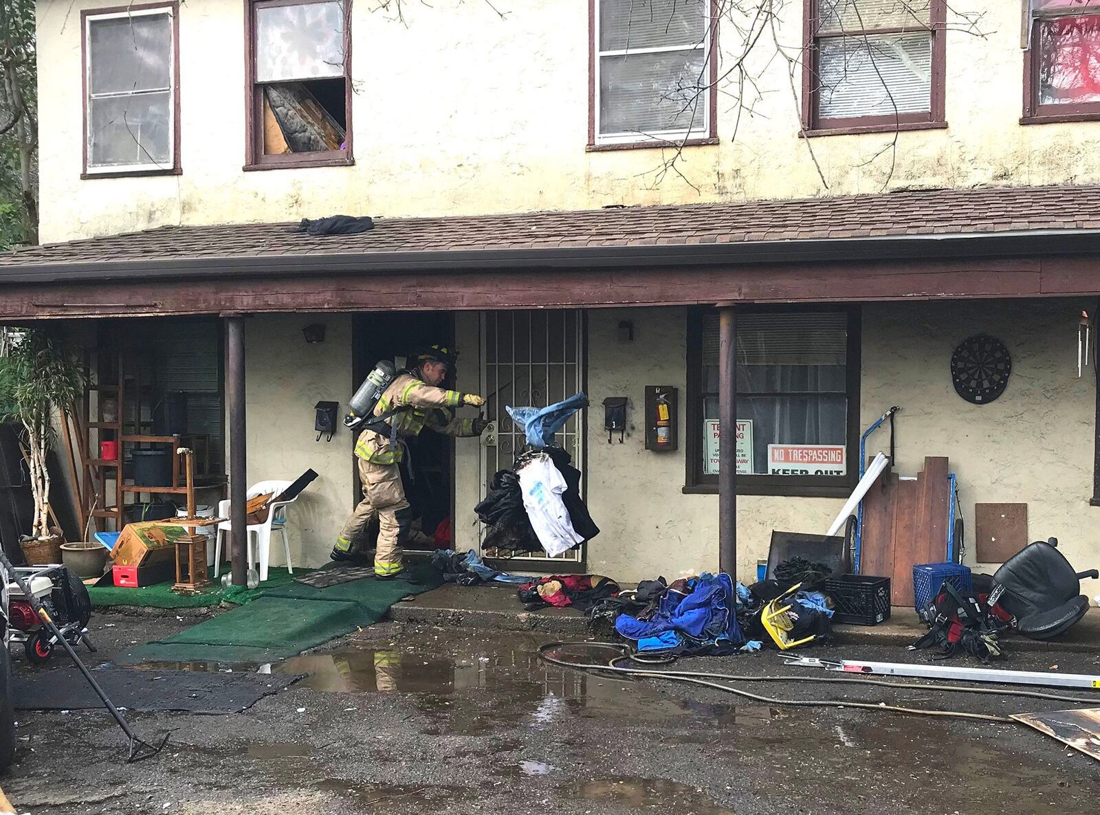 Firefighters clean out an apartment where a fire started Sunday, Jan. 7, 208, when a resident tried to kill a spider using a torch lighter.