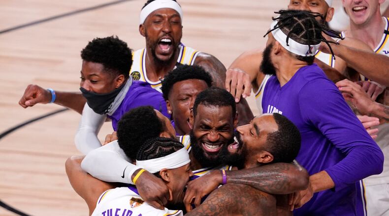 Los Angeles Lakers' LeBron James (23) celebrates with his teammates after the Lakers defeated the Miami Heat 106-93 in Game 6 of basketball's NBA Finals Sunday, Oct. 11, 2020, in Lake Buena Vista, Fla. (AP Photo/Mark J. Terrill)