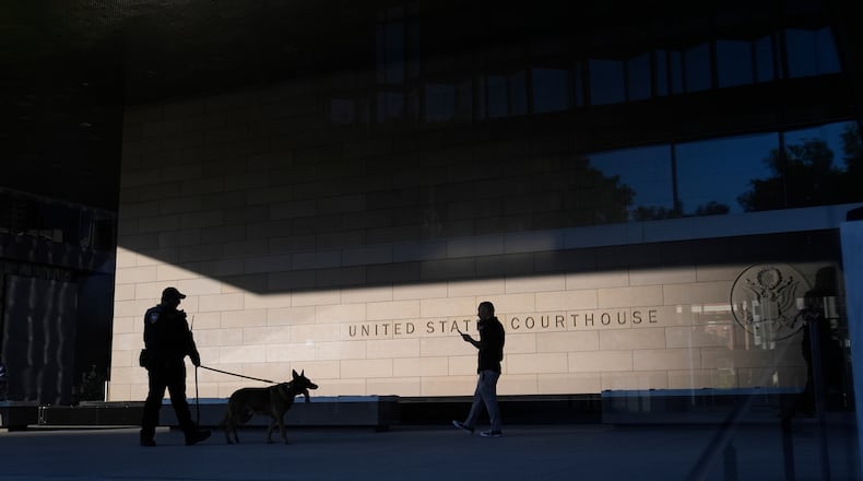 FILE - A police officer inspects the exterior of a federal courthouse with the aid of a canine on Sept. 5, 2024, in Los Angeles. (AP Photo/Jae C. Hong, File)