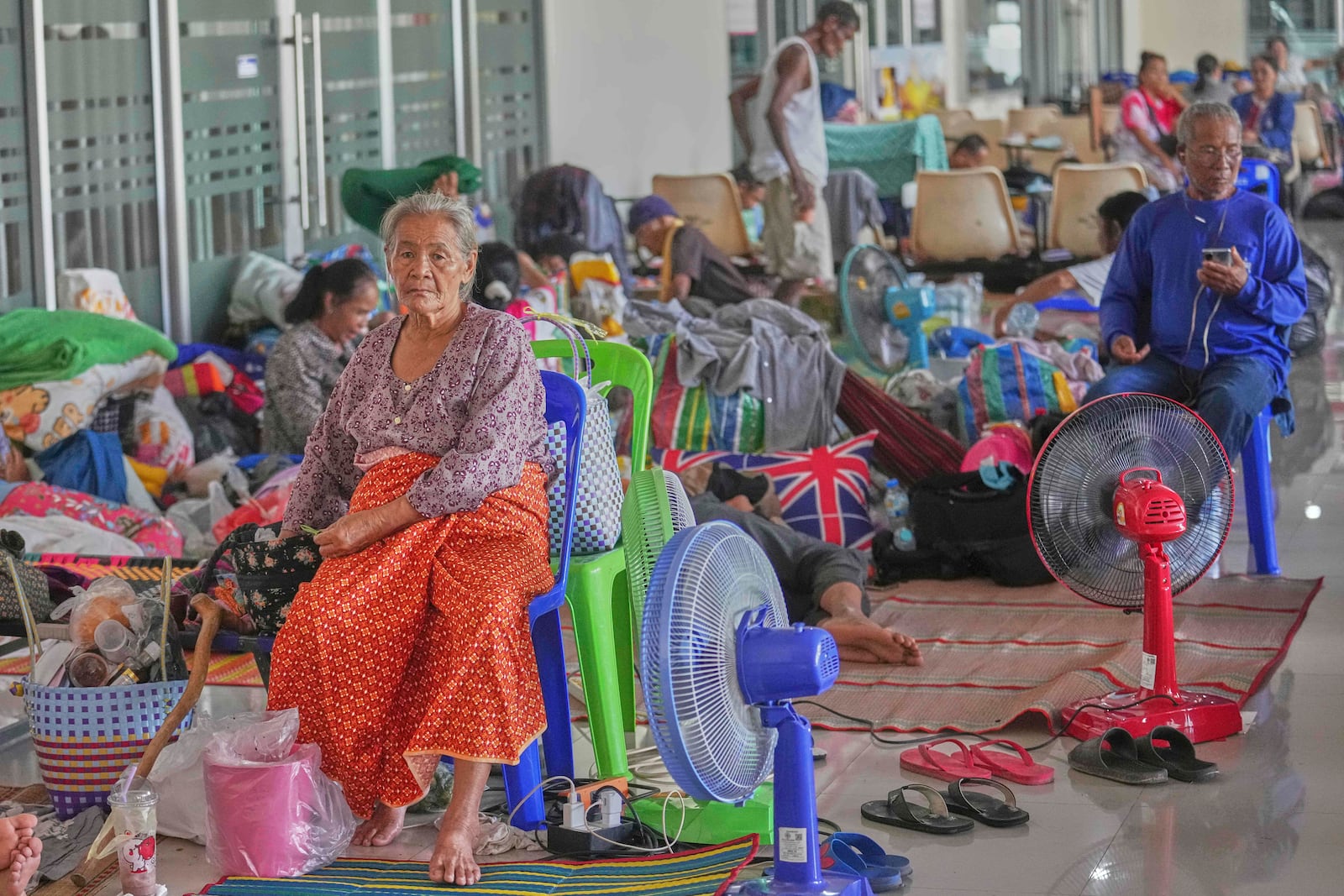 Thai residents who fled homes following the clashes between Thai and Cambodian soldiers rest at an evacuation center in Surin province, Thailand, Monday, July 28, 2025. (AP Photo/Sakchai Lalit)