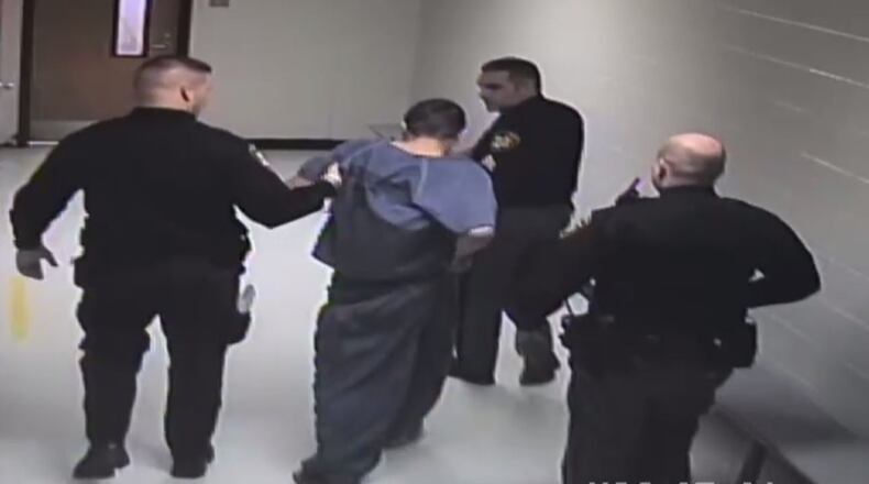 Corrections officers escort Joseph Guglielmo to another cell for observation after he is injured in a fight with a jail sergeant. Guglielmo sued the county, saying he is confined to a wheelchair after being beaten in the jail.