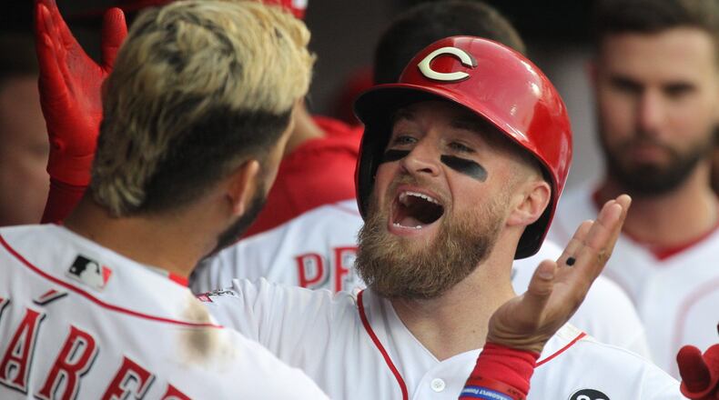 The Reds��� Tucker Barnhart celebrates with Eugenio Suarez after hitting a home run in the fourth inning against the Braves on Tuesday, April 23, 2019, at Great American Ball Park in Cincinnati. David Jablonski/Staff