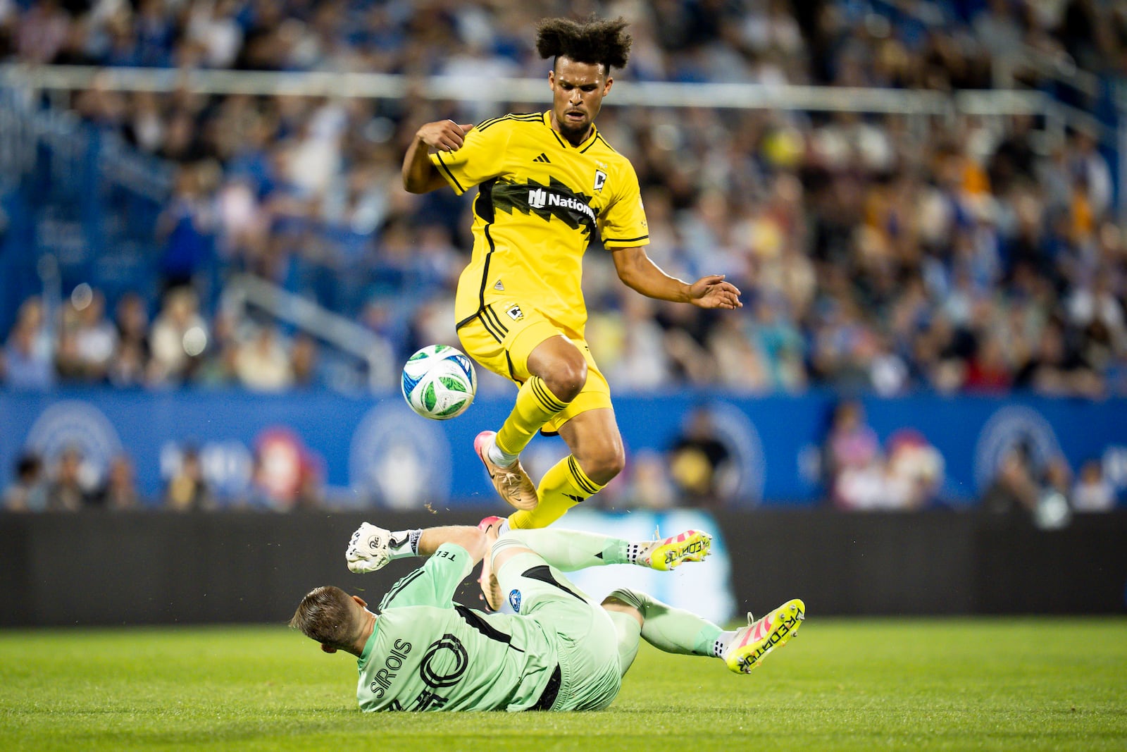 Columbus Crew Jacen Russell-Rowe (19) jumps over CF Montréal goalkeeper Jonathan Sirois (40) to score during second half MLS soccer action in Montreal, Quebec, Wednesday, May 14, 2025. (Christopher Katsarov/The Canadian Press via AP)