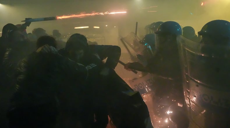 Demonstrators clash with police during a protest against the Milan-Cortina 2026 Olympics, in Milan, Italy, Saturday Feb. 7, 2026. (Claudio Furlan/LaPresse via AP)