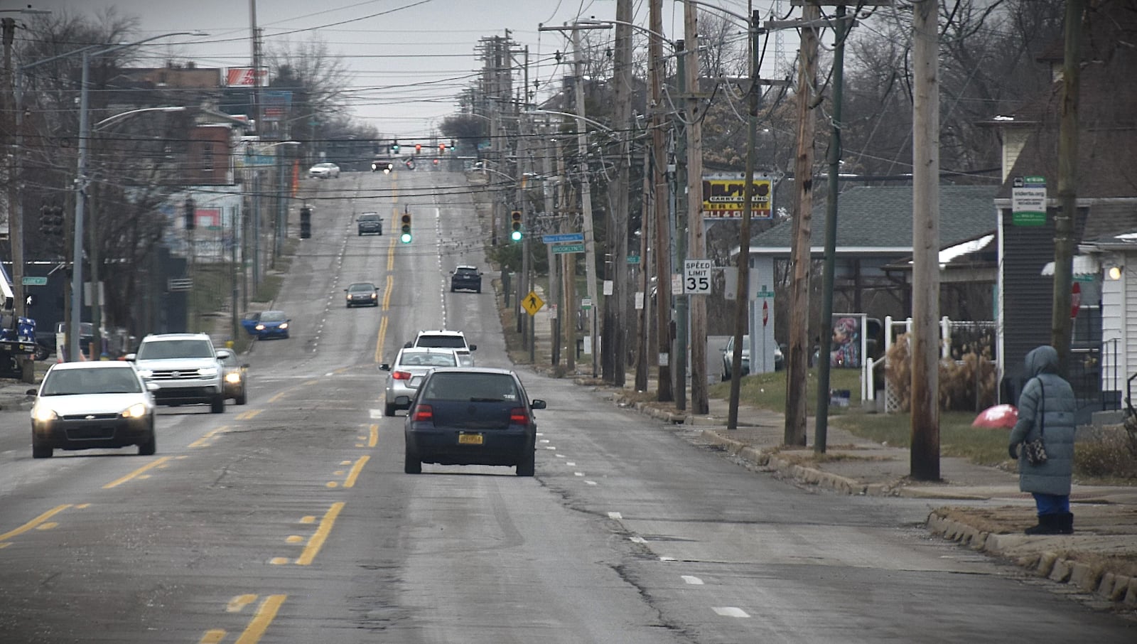 A woman waits at a bus stop on West Third Street not far from the Wright brothers airplane factory site in West Dayton. CORNELIUS FROLIK / STAFF