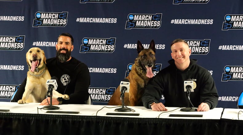 Keeping the NCAA Tournament’s First Four safe: Dayton K-9 officer North, his partner Detective Ross Nagy and Dayton K-9 officer Scooby Doo with his partner, Officer Nathan Speelman, sit on the dais at the First Four ready for any questions – or safety challenges – that come up during the marque hoops event at UD Arena. CONTRIBUTED