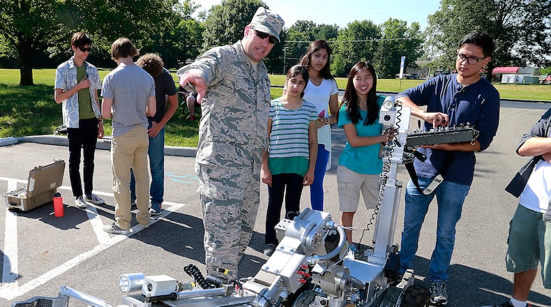 Clark County high school students participating in the Johns Hopkins Engineering Innovation Program at Clark State Community College got the chance to control the robot used by the Wright Patterson Air Force Base EOD team or “bomb squad” Tuesday, July 19, 2016. Guiding the students with the robot is StSgt. Nicholas Scheer. The Dayton Police Department’s bomb squad was also on hand demonstrating their robots for the students. BILL LACKEY/STAFF