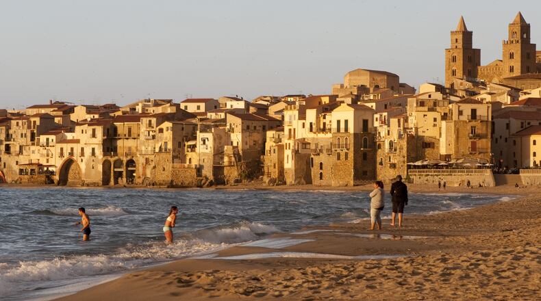 The beach at Cefalu, Italy, a picturesque town in Sicily, May 19, 2016. For older travelers, the best thing about returning to a well-known destination is that you lose the greedy compulsion to go everywhere and see everything. (Susan Wright/The New York Times)