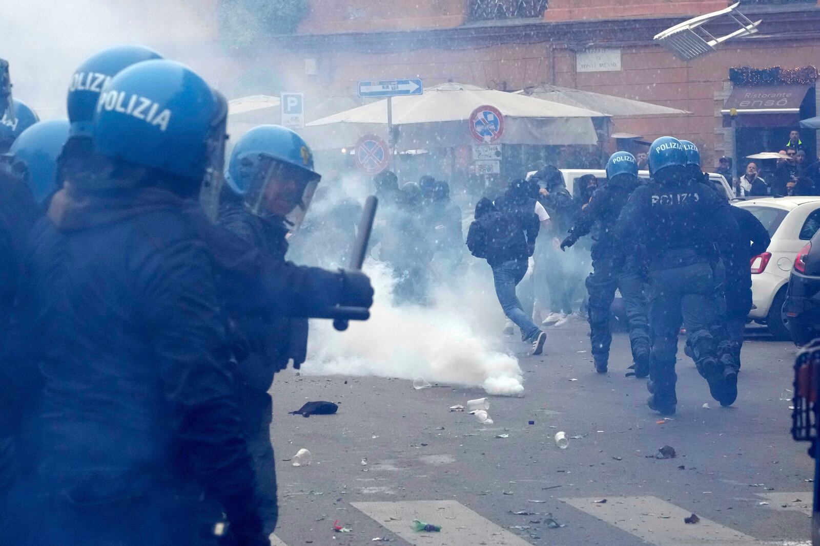Lazio fans clash with Italian Policemen in riot gear outside the olympic stadium prior to the start of the Italian Serie A soccer match between Lazio and Roma in Rome, Sunday, April 13, 2025. (AP Photo/Gregorio Borgia)