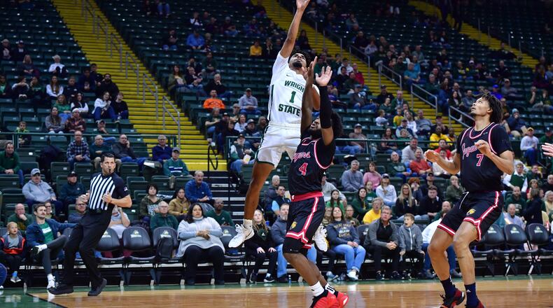 Wright State's Trey Calvin shoots over IUPUI's Bryce Monroe (4) and Qwanzi Samuels during a game at the Nutter Center on Nov. 29, 2023. Wright State Athletics photos