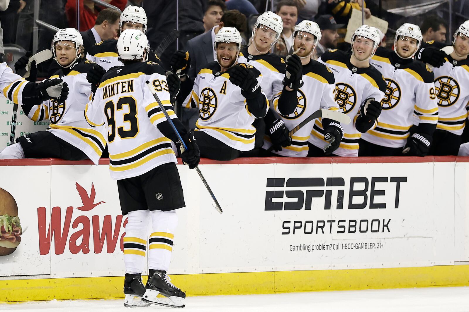 Boston Bruins center Fraser Minten (93) celebrates with teammates after scoring a goal in the third period of an NHL hockey game against the New Jersey Devils Tuesday, April 8, 2025, in Newark, N.J. (AP Photo/Adam Hunger)