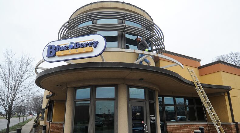 Marc Robinson of Wilcon Construction places The Blue Berry Cafe sign on the old Golden Nuggent Pancake House in Kettering Wednesday, Jan. 3, 2024. MARSHALL GORBY\STAFF