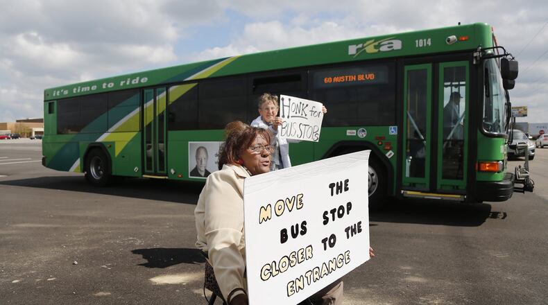 Marsha Johnson, front, and Paula Ewers, both with the group Leaders for Equality and Action in Dayton, protest the lack of a bus stop close to an entrance at the Dayton Mall in Miami Twp. CHRIS STEWART / STAFF