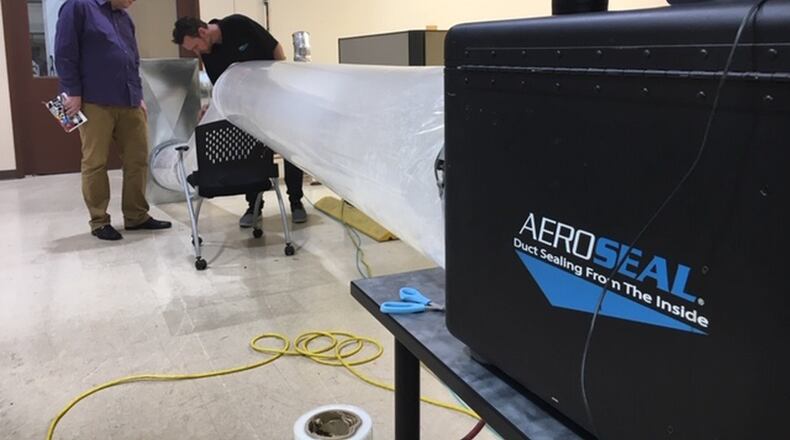 From left, Kevin Dugan, marketing director for Miamisburg company Aeroseal, and Matt Damron, Aeroseal strategic account manager, run a test in the duct-sealing technology company’s demonstration area. THOMAS GNAU/STAFF