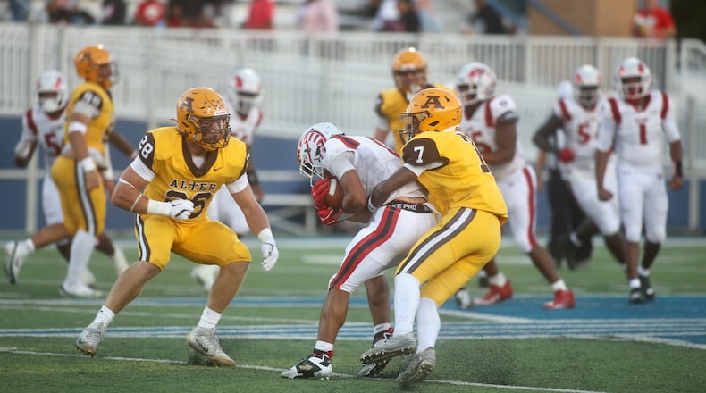 Alter's Quardrell Thomas tackles Trotwood-Madison's Armani Rogers on Friday, Sept. 12, 2025, at Roush Stadium in Kettering. David Jablonski/Staff