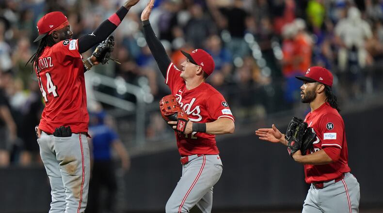 Cincinnati Reds' Elly De La Cruz, left, celebrates with Austin Hays, center, and Connor Joe after a baseball game against the New York Mets Friday, July 18, 2025, in New York. (AP Photo/Frank Franklin II)