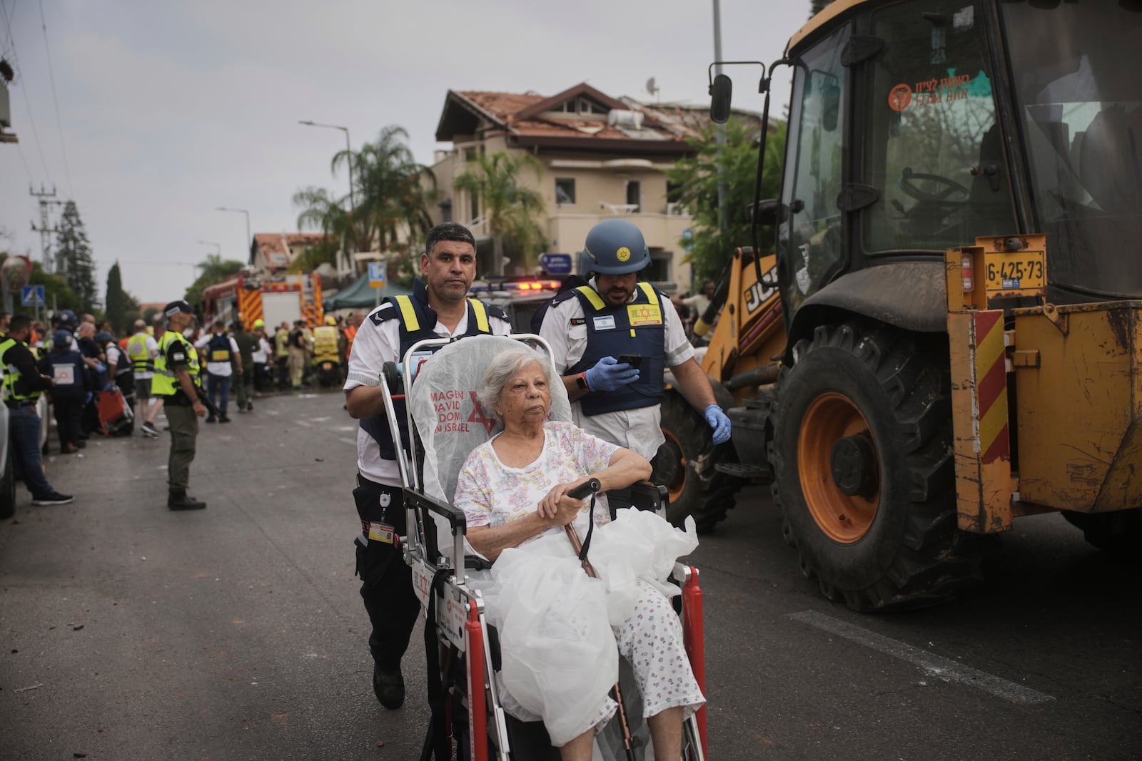Paramedics evacuate a woman from a site that was struck by a missile fired from Iran, in Rishon Lezion, Israel, on Saturday, June 14, 2025. (AP Photo/Ohad Zwigenberg)