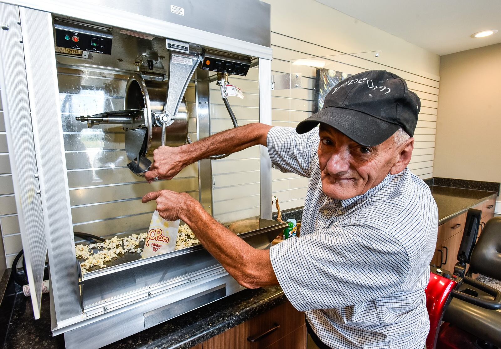 Lynn “Popcorn” Weber serves popcorn from the machine near the movie theater at Otterbein Senior Life. His nickname, Popcorn, was given to him in high school when he ran the concession stand for sporting events. 
