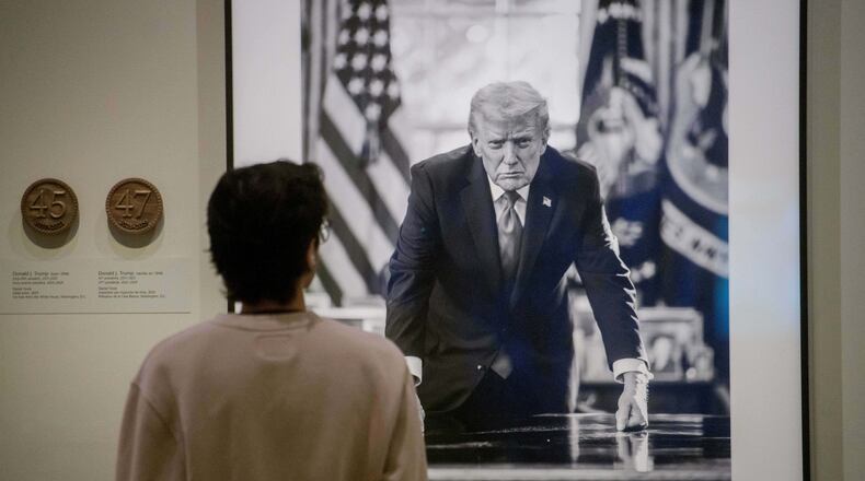 A visitor stops to look at a photograph of President Donald Trump and a short plaque next to it are on display at the Smithsonian's National Portrait Gallery's "American Presidents" exhibit on Sunday, Jan. 11, 2026 in Washington. (AP Photo/Rod Lamkey, Jr.)