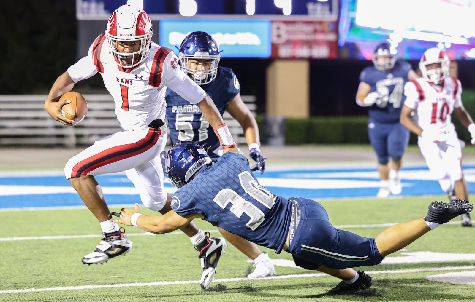 Trotwood-Madison senior quarterback Dallas Shehee runs while trying to avoid Fairmont's Connor Robinson during a nonconference game on Friday, Aug. 29 at Roush Stadium in Kettering. Shehee scored while scrambling on a two-point conversion try to lift the Rams to a 22-21 win. BRYANT BILLING / STAFF