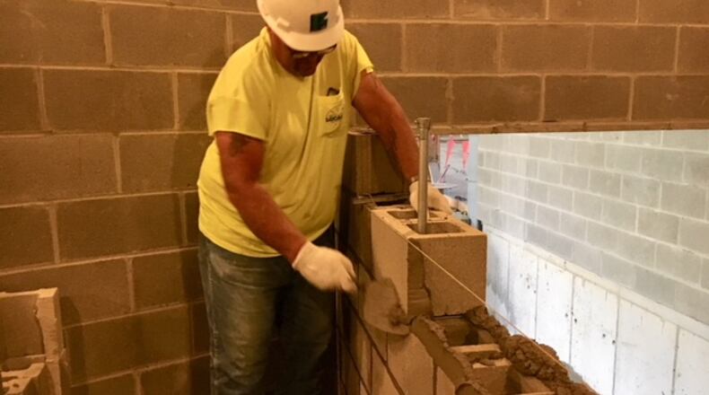 Jerry Carroll, a mason, builds a wall at a Shook-Touchstone construction site at Fairmont High School in this August 2018 file photo. THOMAS GNAU/STAFF