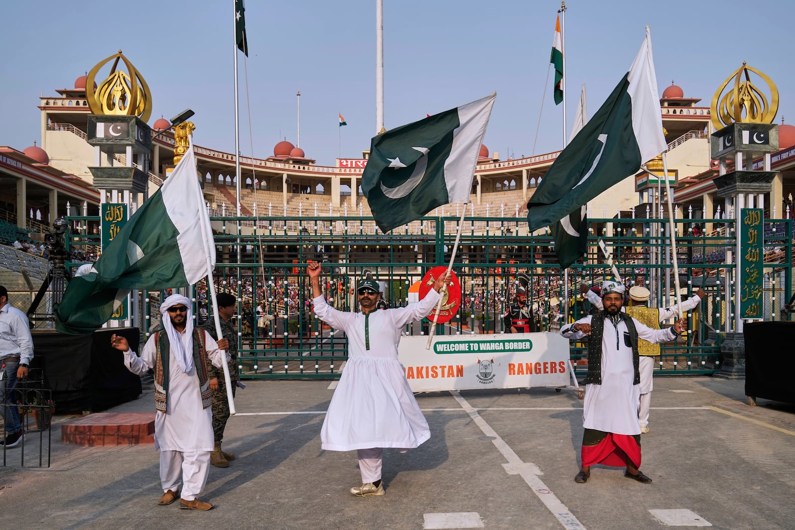 Pakistan's folk dancers perform with national flag during a daily closing ceremony at the Wagah, a joint post on the Pakistan and India border, near Lahore, Pakistan, Saturday, May 3, 2025. (AP Photo/K.M. Chaudary)