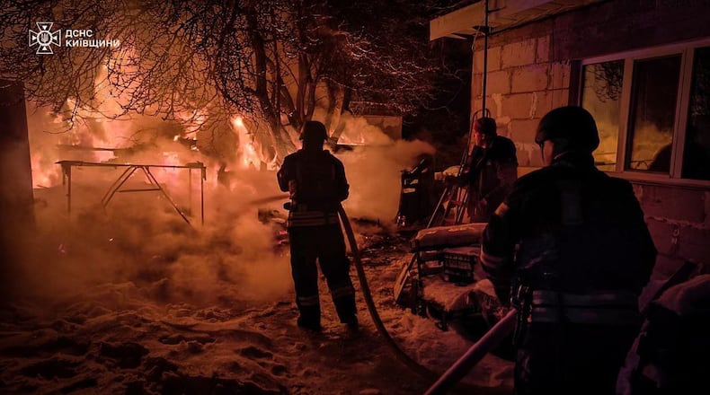 In this photo provided by the Ukrainian Emergency Service, emergency services personnel work to extinguish a fire following a Russian attack in Kyiv region, Ukraine, Tuesday, Jan. 13, 2026. (Ukrainian Emergency Service via AP)
