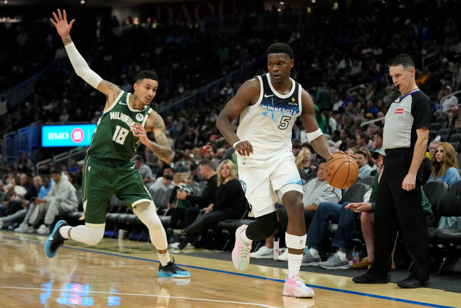 Minnesota Timberwolves' Anthony Edwards (5) dribbles past Milwaukee Bucks' Kyle Kuzma during the second half of an NBA basketball game Tuesday, April 8, 2025, in Milwaukee. (AP Photo/Aaron Gash)