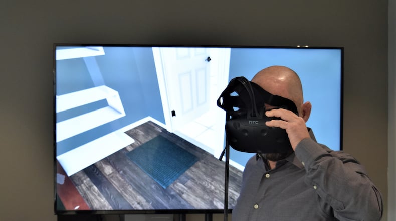 Miamisburg-headquartered Marxent develops software to help consumers visualize furniture at stores like La-Z-Boy and Macy’s using augmented and virtual reality. Co-founder and chief technology officer Barry Besecker uses virtual reality to look at furniture in a home. STAFF PHOTO / HOLLY SHIVELY