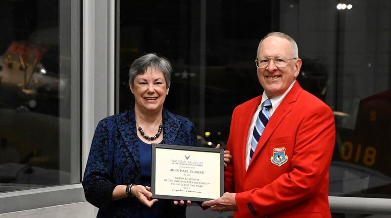 John P. Clarke (in red jacket) received the 2021 Director’s Award for Volunteer of the Year for his dedication and excellence in serving the National Museum of the U.S. Air Force. U.S. AIR FORCE PHOTO/TY GREENLEES