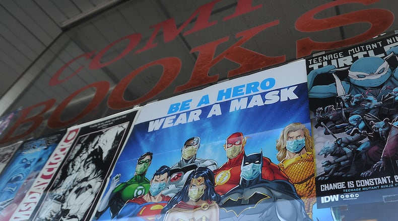 The sign 'Be A Hero Wear A Mask'  greets customers at the Mavericks comic book shop in Kettering. MARSHALL GORBY\STAFF